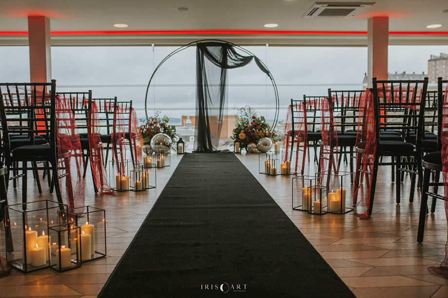 Moody red and black ceremony set up with candles and altar hoop